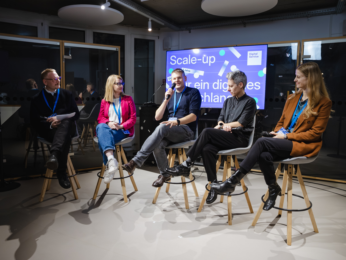 Die Teilnehmenden des Panels sitzen vor einer Leinwand mit der Aufschrift „Scale-up für ein digitales Deutschland“ und diskutieren