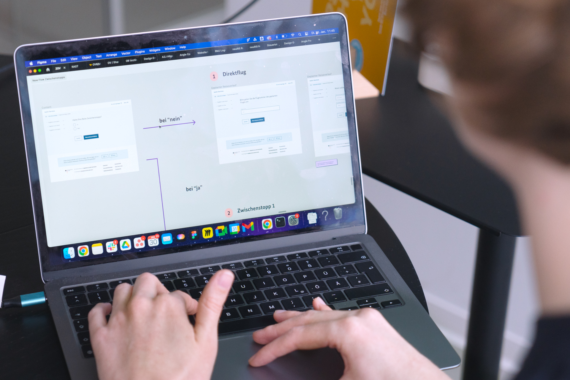 Eine Person wird im Anschnitt gezeigt, wie sie an ihrem Laptop arbeitet. Der Desktop zeigt eine Nutzendenreise für ein Online-Formular zu Fluggastrechten – Pfad 1 führt zu „Direktflug