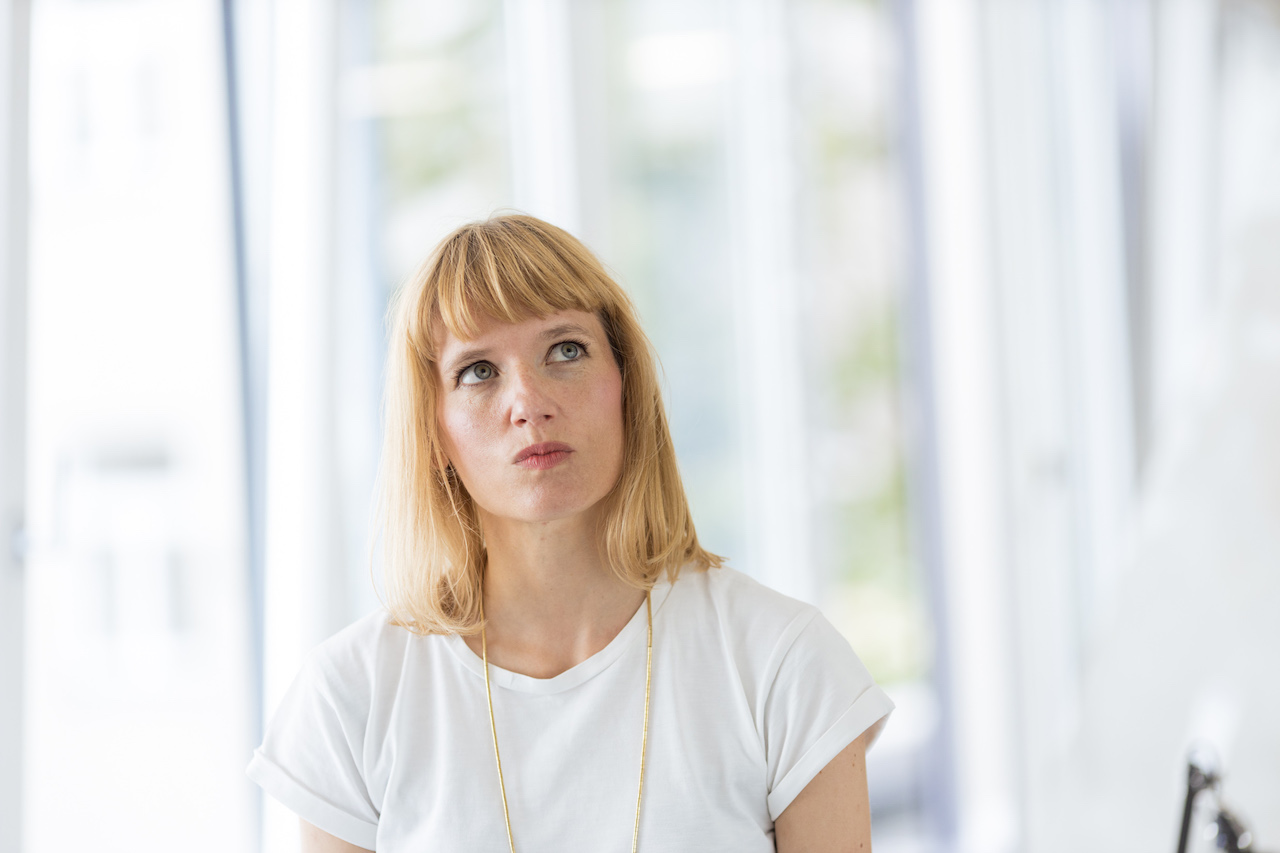 Senior UX designer Charlotte looks thoughtfully past the camera. At the same time, she makes a face.