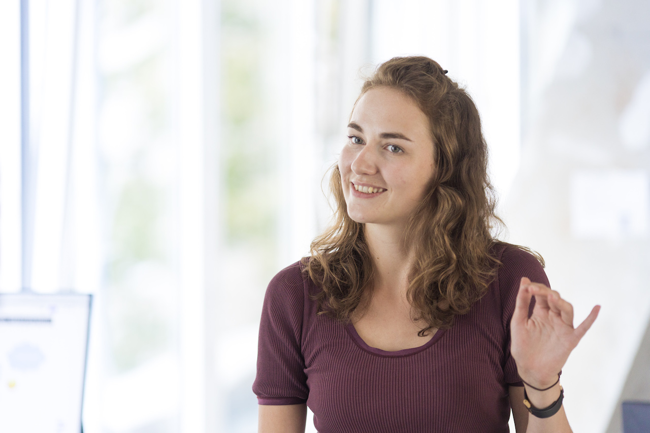 Frederike gestures with one hand.