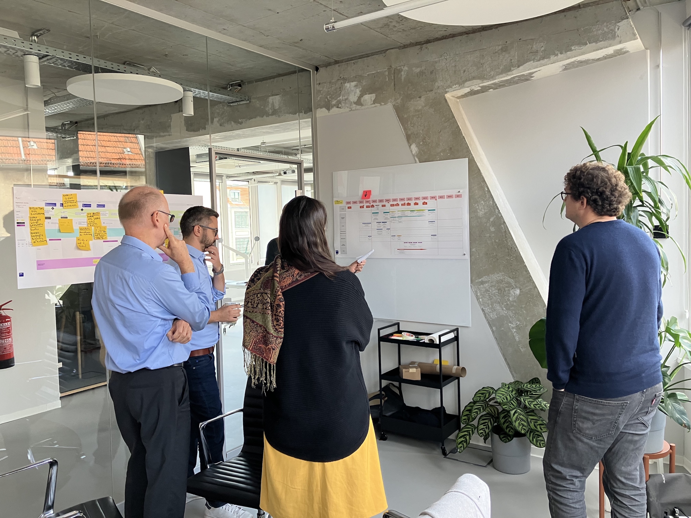 Four people in an office space discussing a project roadmap