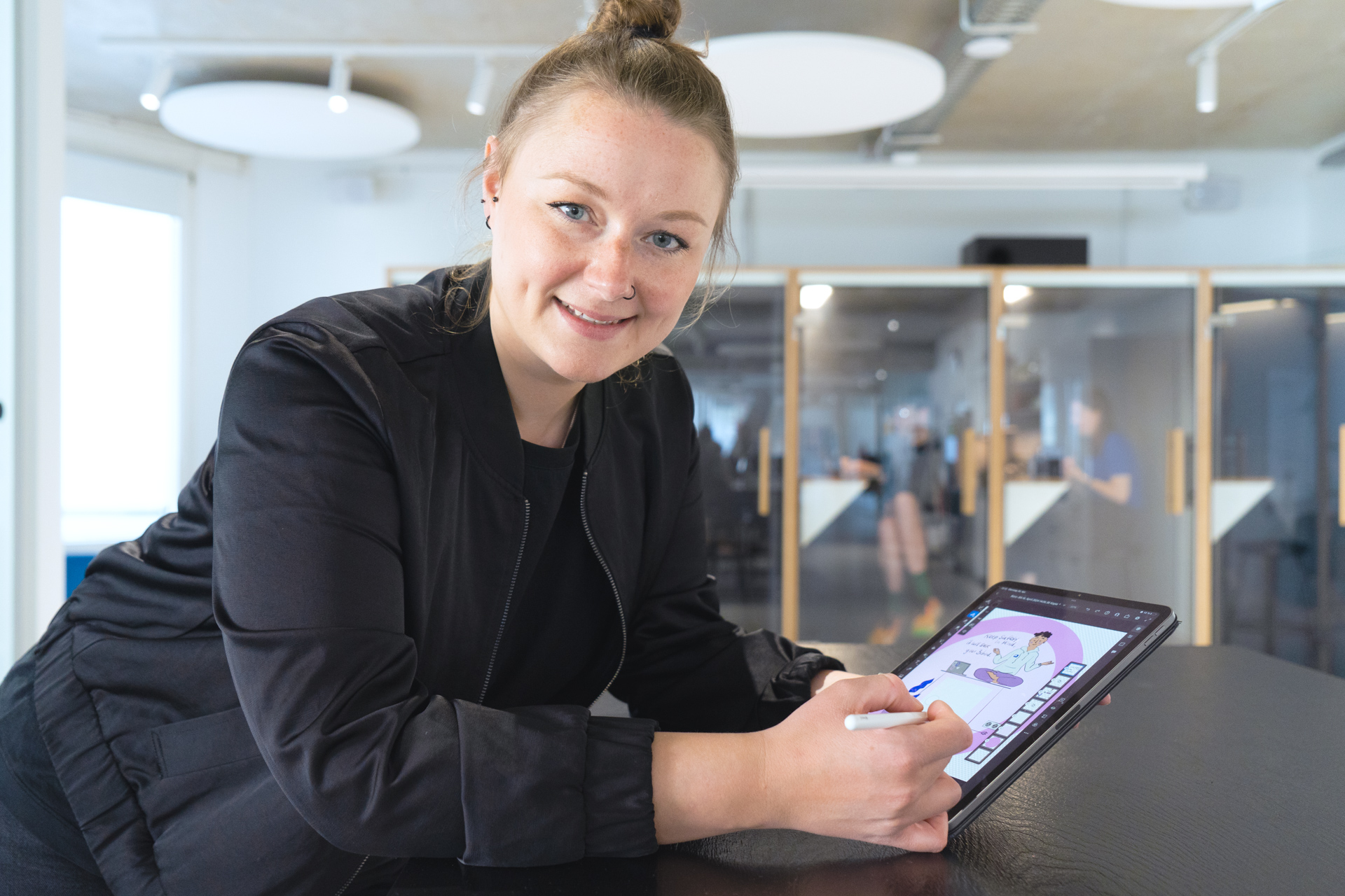 Autorin Franziska steht im Büro des DigitalService an einem Tisch und zeichnet auf einem Tablet an einer Skizze