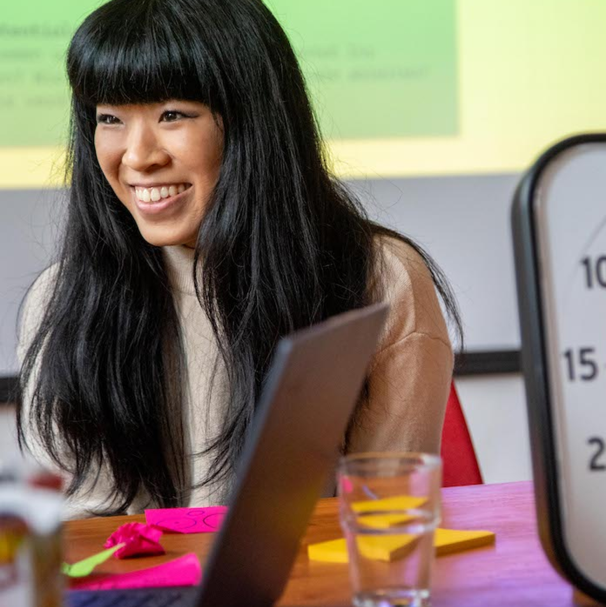 A young fellow sits at a table; in front of her are colorful post-its.