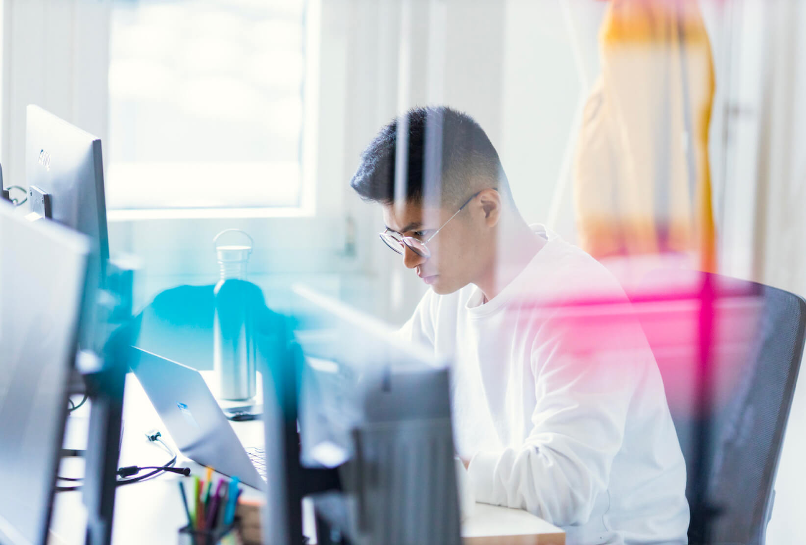 A DigitalService employee sits at an office desk, concentrating on his work