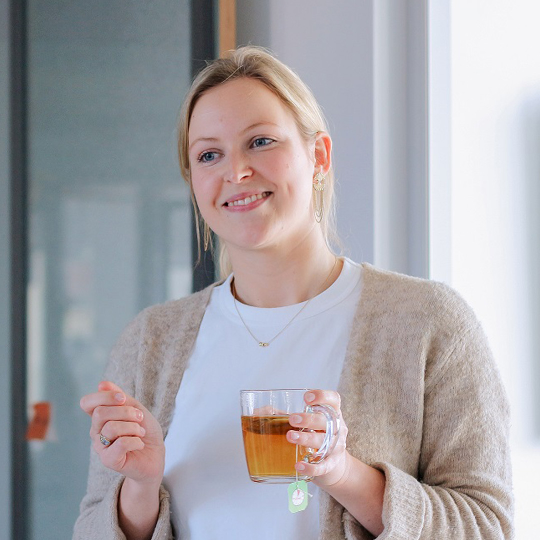 Interviewee Annemie standing with a cup of tea in the DigitalService office.