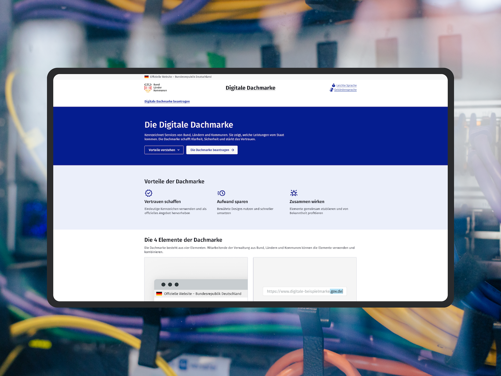 Screenshot of the “Unified Digital Brand” website on a mock-up of a screen; as a visual element, the DigitalService office can be seen in the background
