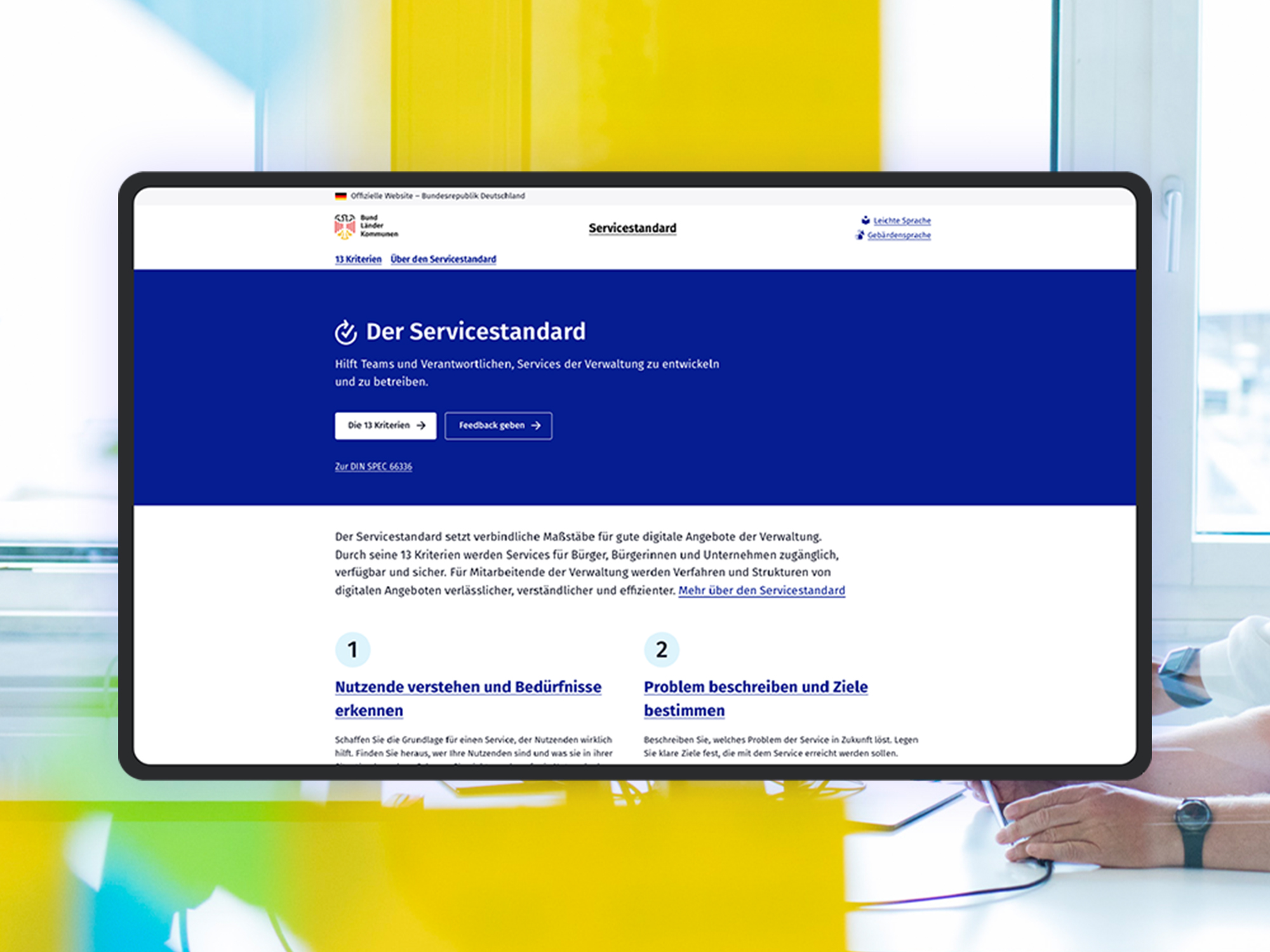 Ein Screenshot der aktuellen Beta-Version der Servicestandard Website; als visuelles Stilmittel sieht man im Hintergrund das Büro des DigitalService.